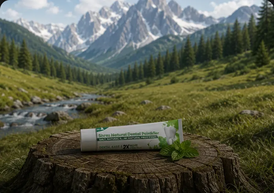 Shraz Natural Dental Painkiller packaging photographed on a tree stump in a mountain valley
